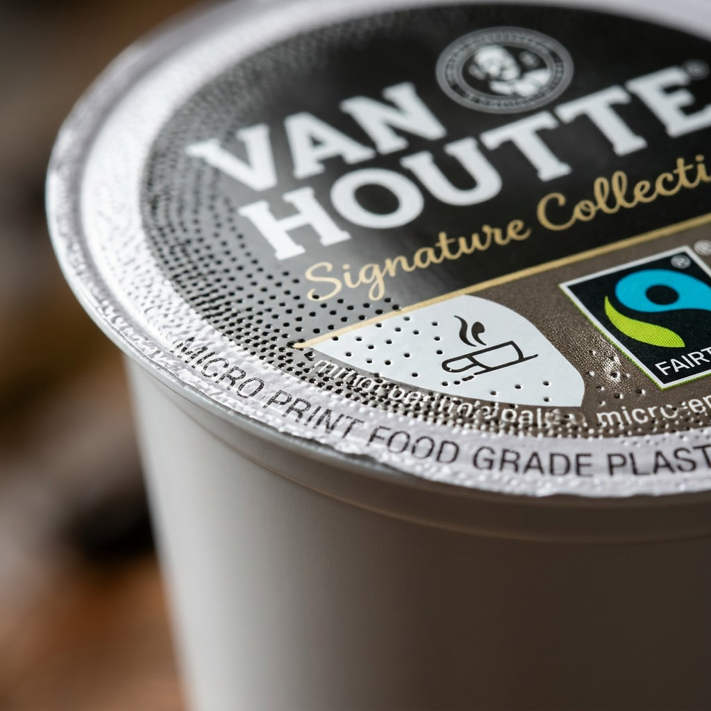 Macro detail of a Van Houtte Espresso Superiore K-Cup pod focal on the seal and Fair Trade logo.
