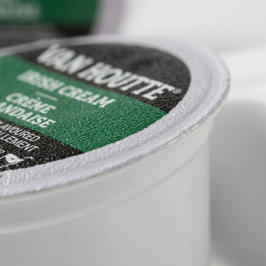 Macro close-up of a Van Houtte Irish Cream K-Cup pod showing the textured foil seal and white rim.
